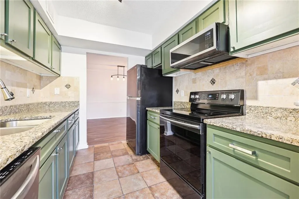 The eat-in galley kitchen is ready for you to prepare your favorite meals, offering granite countertops, stainless steel appliances, and a travertine backsplash that compliments the space.