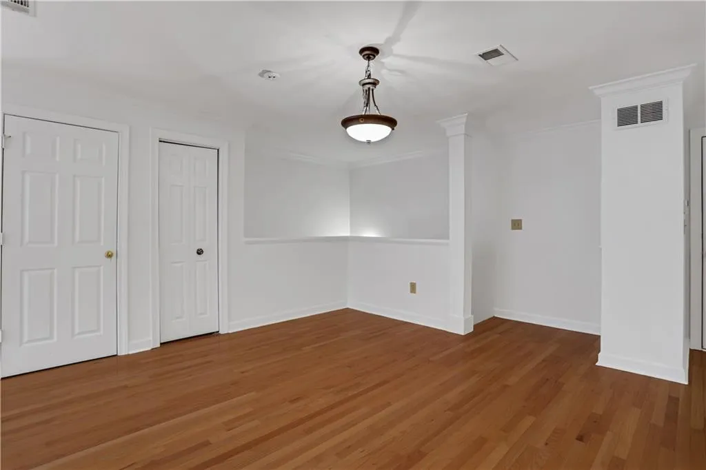 Unfurnished dining area with light wood finished floors and crown molding