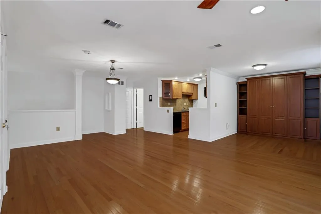 Unfurnished living room featuring wood finished floors, ceiling fan, ornamental molding, and recessed lighting