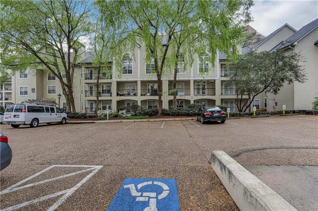 View of apartment building / complex with uncovered parking