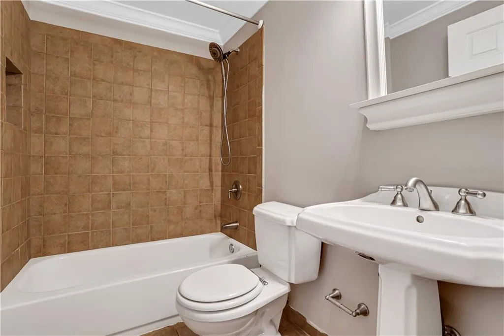 Bathroom with shower / bath combination and ornamental molding