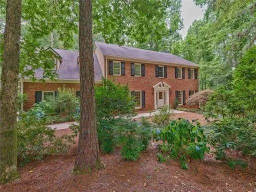 Colonial home featuring brick siding