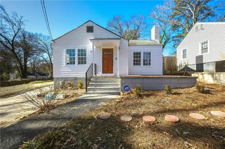 White siding exterior with a prominent brown entry door and a front porch