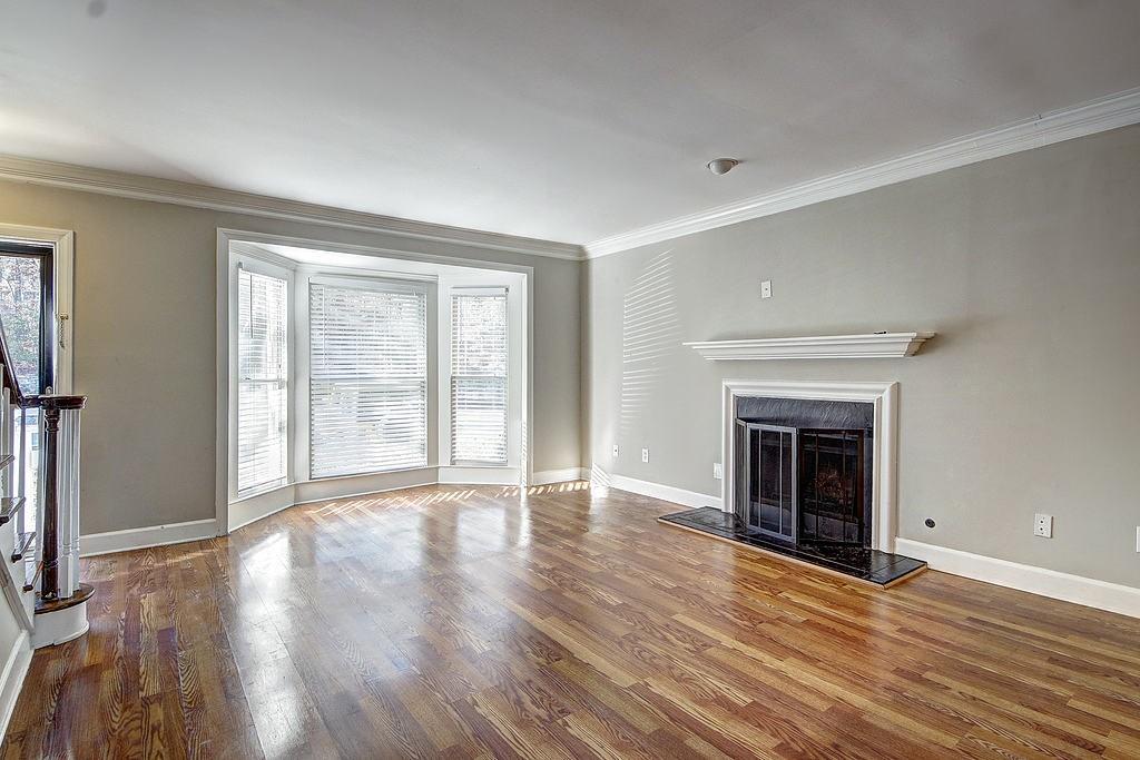 Unfurnished living room with crown molding and dark hardwood / wood-style flooring