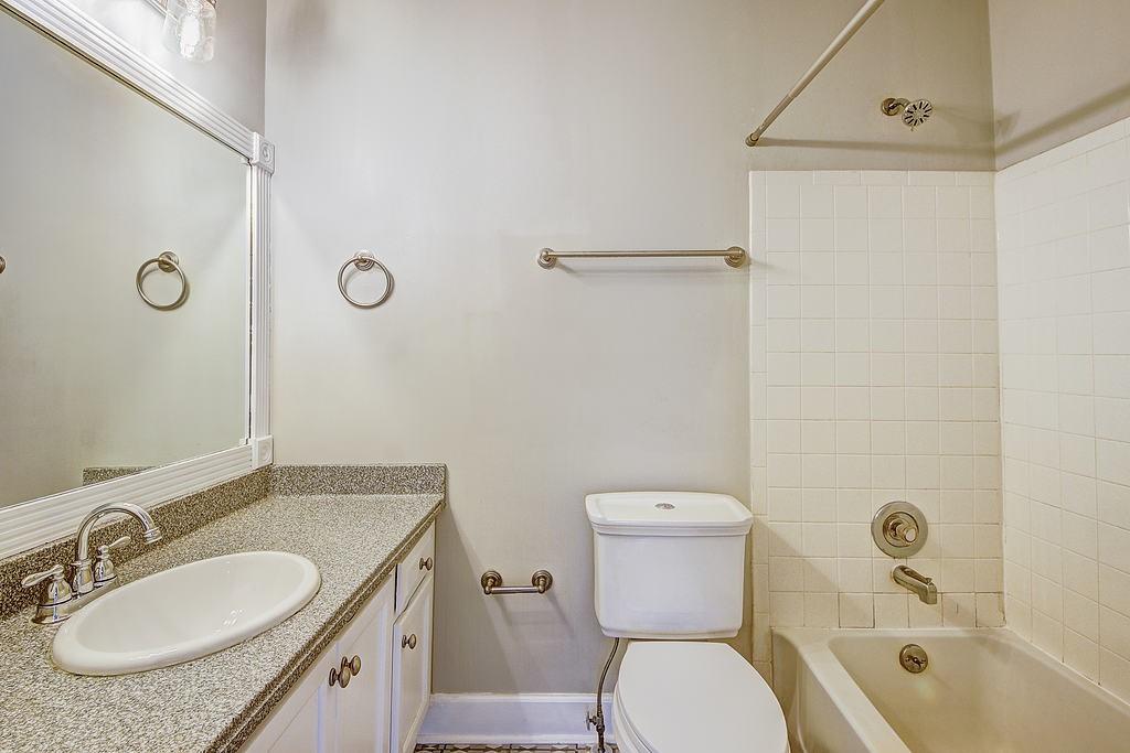 Full bathroom with tiled shower / bath, toilet, and vanity