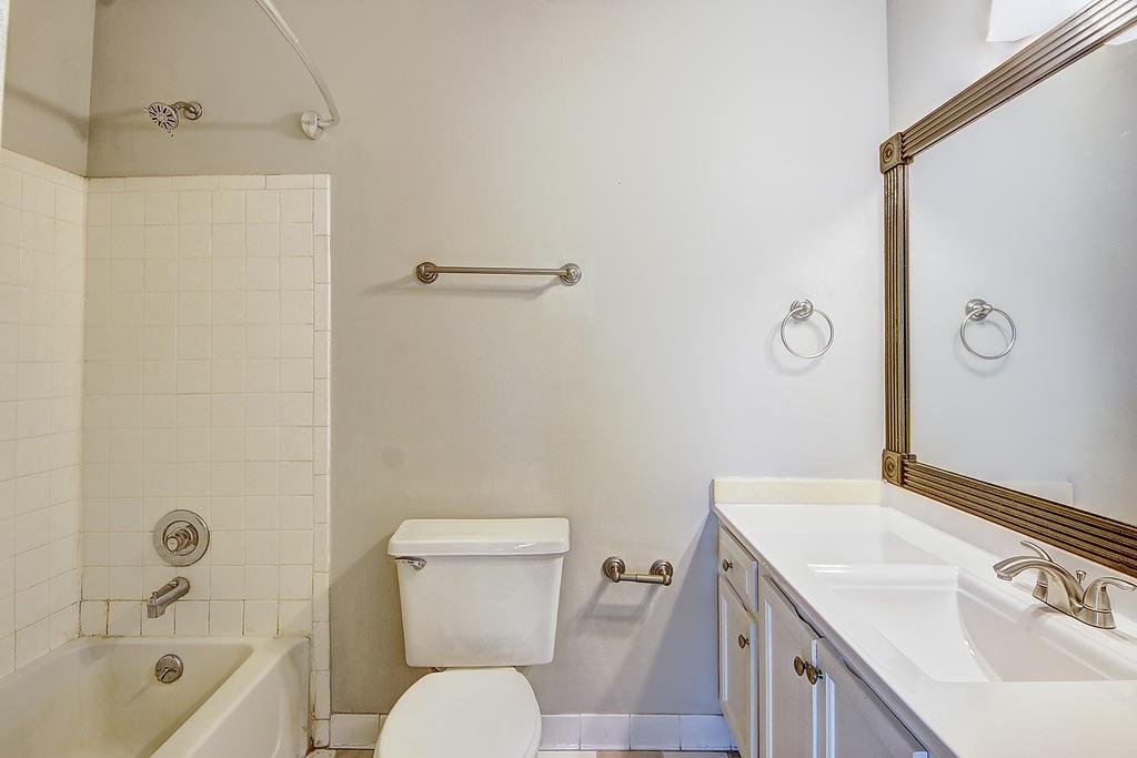 Full bathroom with tile floors, tiled shower / bath, toilet, and vanity