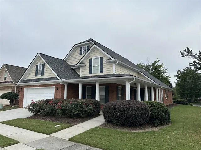 Brick and siding exterior with a dark shingled roof