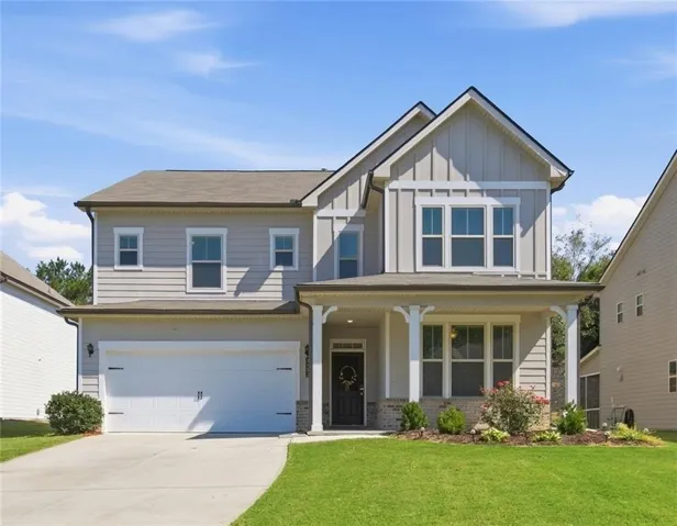 Two-story home featuring a covered front porch, a two-car garage, and an architectural shingle roof