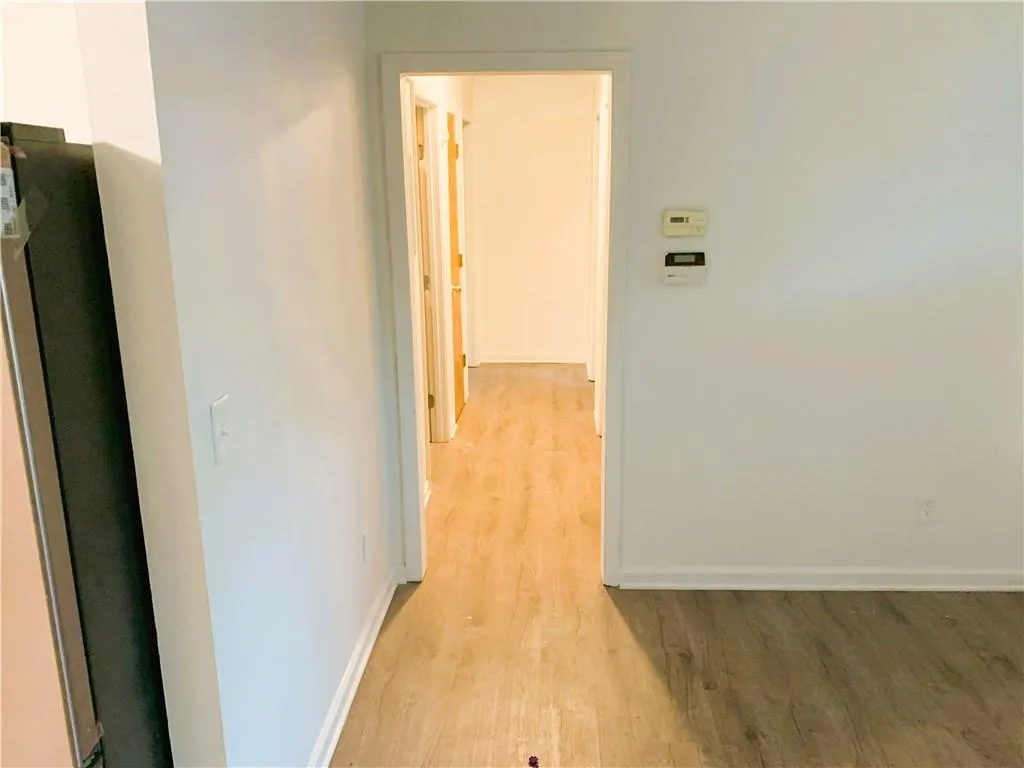 Hall with light wood-style flooring and baseboards
