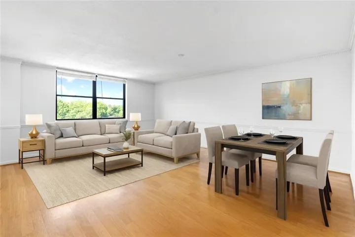 Virtually staged  Living area featuring ornamental molding and light wood finished floors