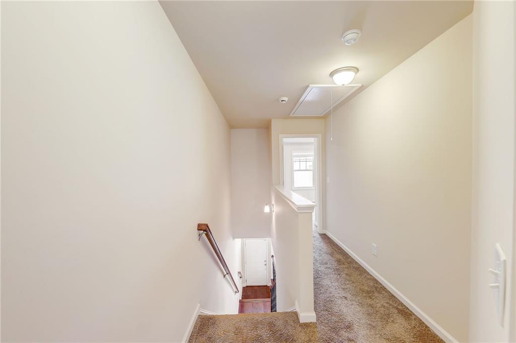 Hallway featuring light carpet