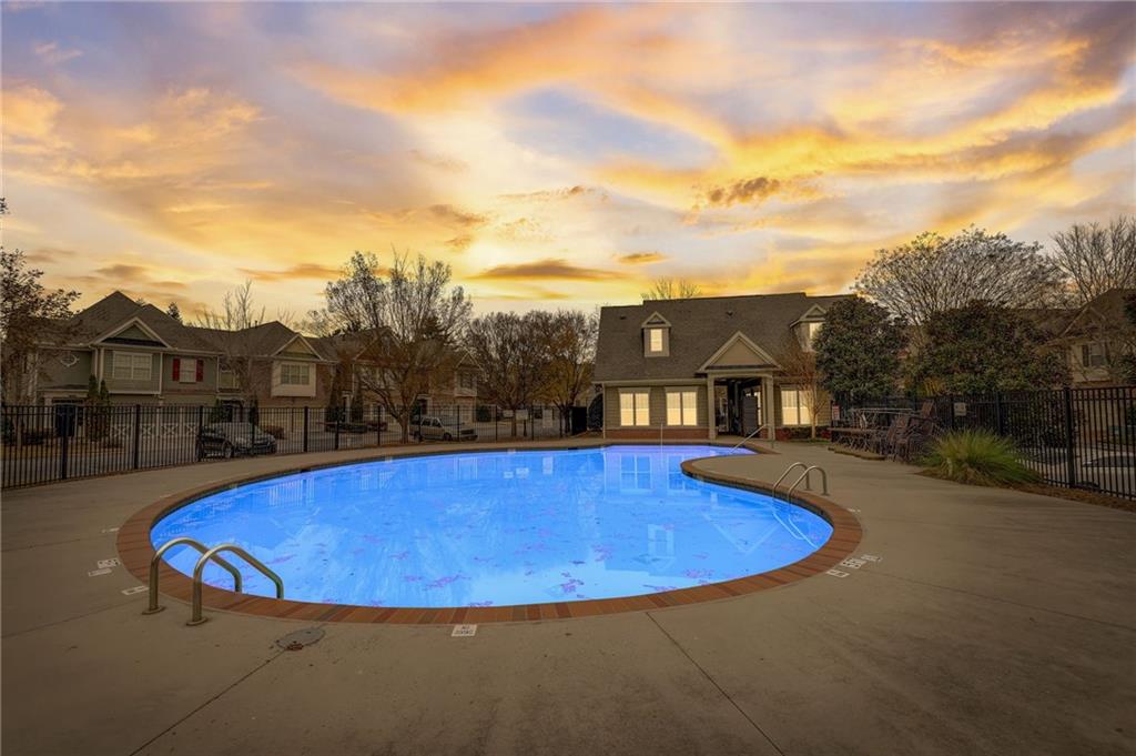 Pool at dusk featuring a patio area