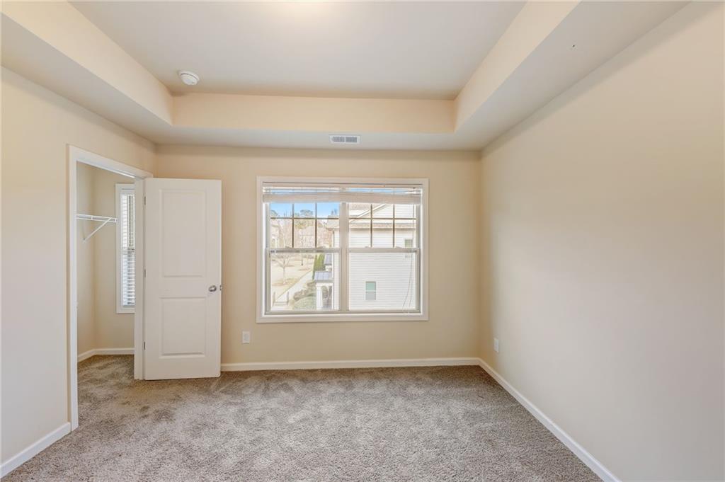 Carpeted spare room featuring a raised ceiling
