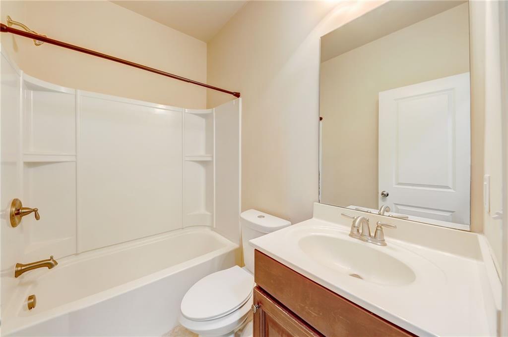 Full bathroom with vanity with extensive cabinet space, toilet, and shower / washtub combination