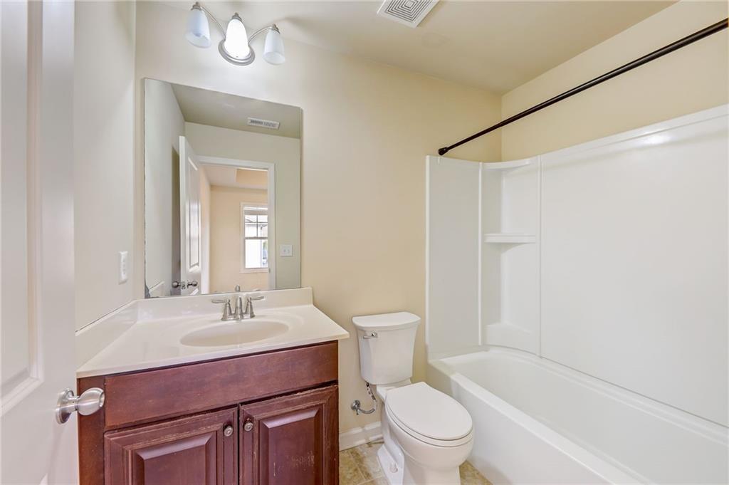 Full bathroom with tile floors, toilet, shower / washtub combination, and oversized vanity