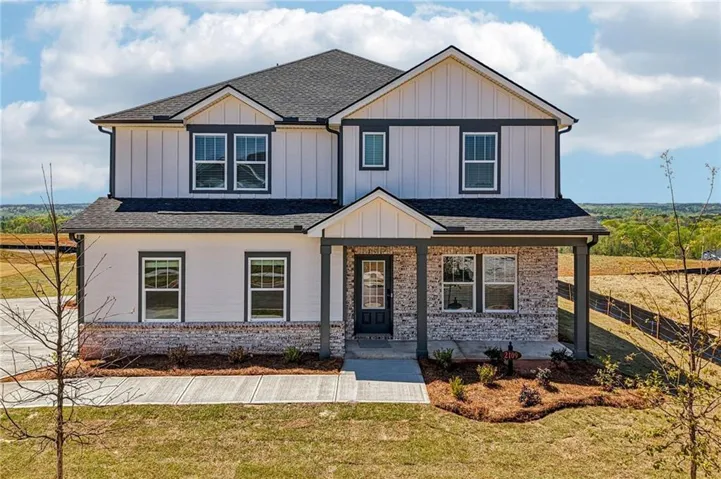 View of front of home featuring roof with shingles, a porch, board and batten siding, and a front lawn