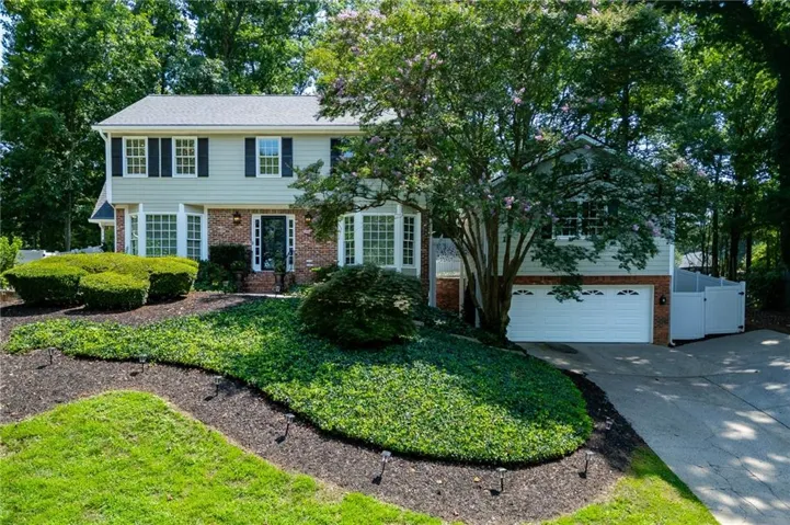 Traditional two-story residence featuring brick and siding facade, bay windows, and a two-car garage