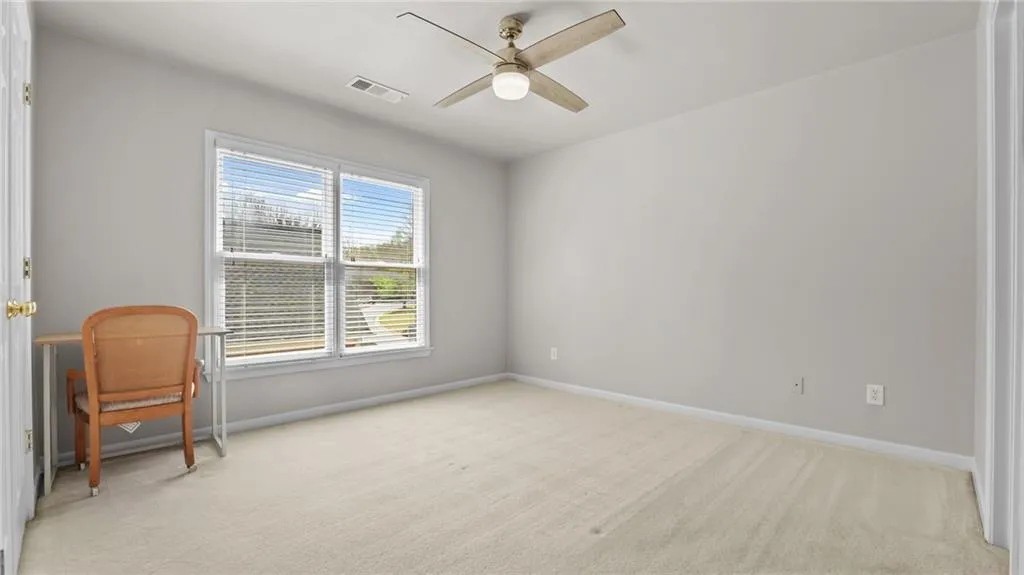 Sitting room with light carpet, baseboards, visible vents, and a ceiling fan