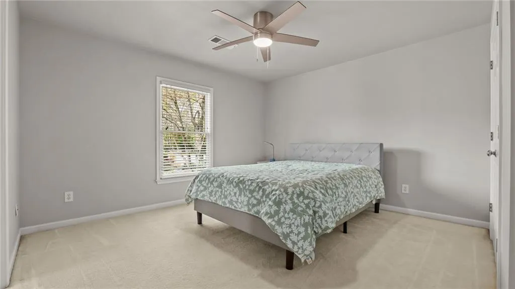 Bedroom with light carpet, baseboards, and visible vents