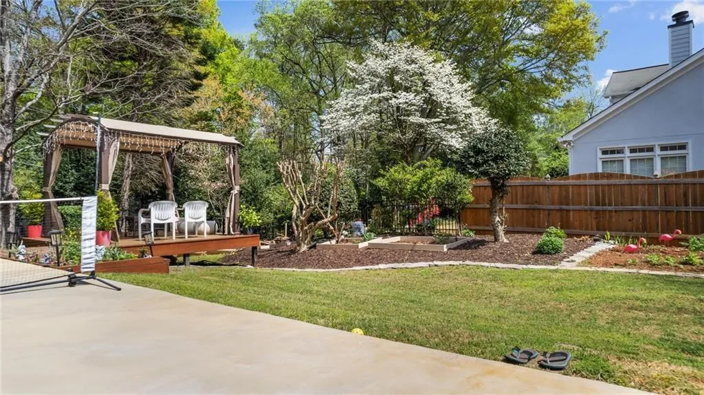 View of yard with a pergola, a deck, fence, and a patio