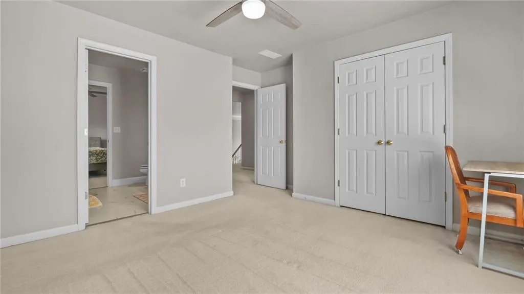 Unfurnished bedroom with baseboards, carpet flooring, ensuite bath, and a closet
