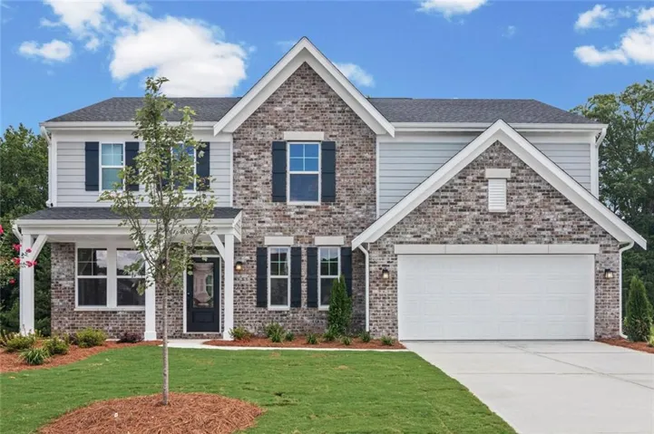 Two-story residence featuring a mixed brick and siding facade, a front-facing attached garage, a covered entry porch, dark shutters, and a concrete driveway