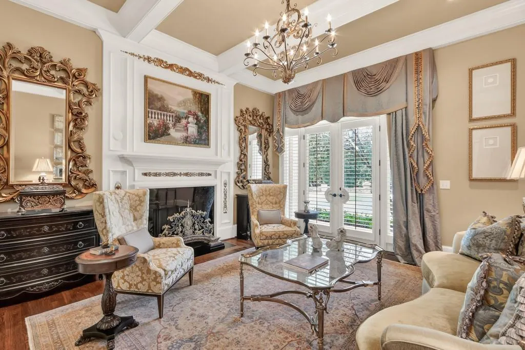 Formal living room with a fireplace and french doors to the veranda and pool