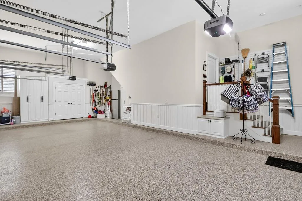 Immaculate 3 car garage with built in storage and floors by Granite Garage Floors.