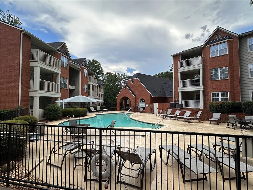 Community swimming pool with surrounding concrete patio and multiple lounge chairs