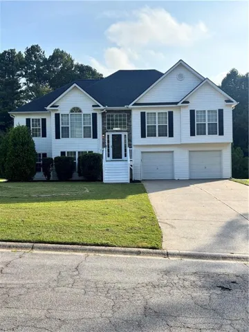 Two-story residence with white siding, dark shutters, and an attached two-car garage