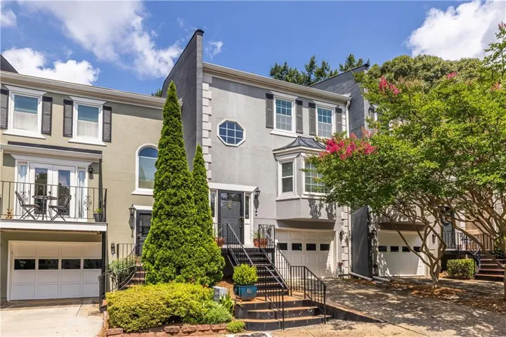 Townhome facade featuring a bay window, decorative shutters, and an octagonal window