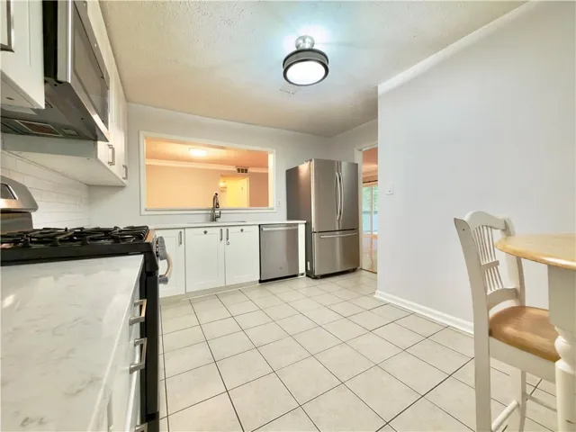 Kitchen featuring white cabinetry, stainless steel appliances