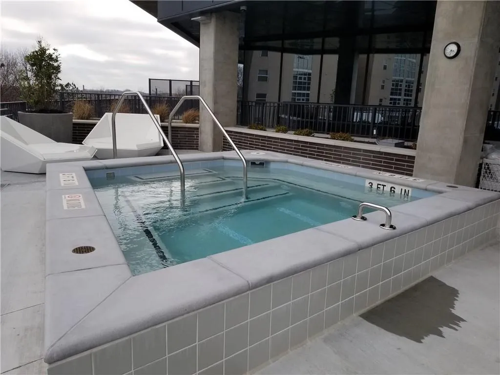 View of swimming pool with a community hot tub