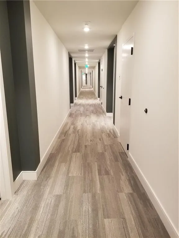 Hallway with light hardwood / wood-style floors