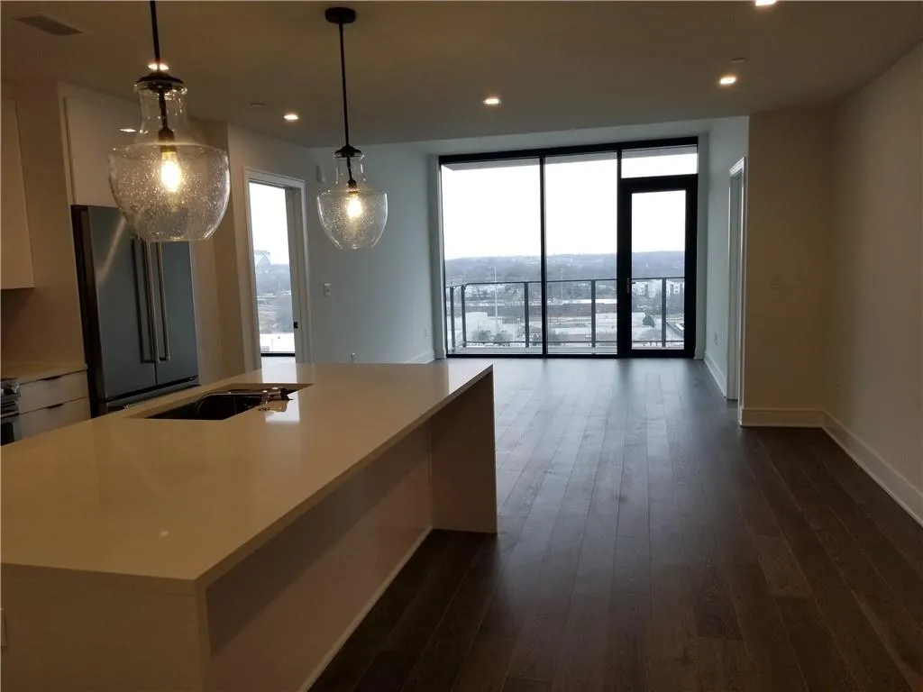 Kitchen featuring pendant lighting, dark hardwood / wood-style floors, high end fridge, and white cabinets