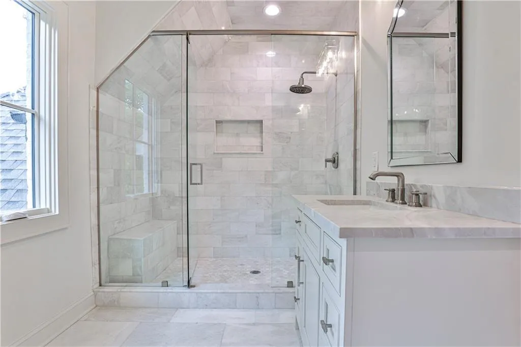 Bathroom featuring walk in shower, tile flooring, and vanity