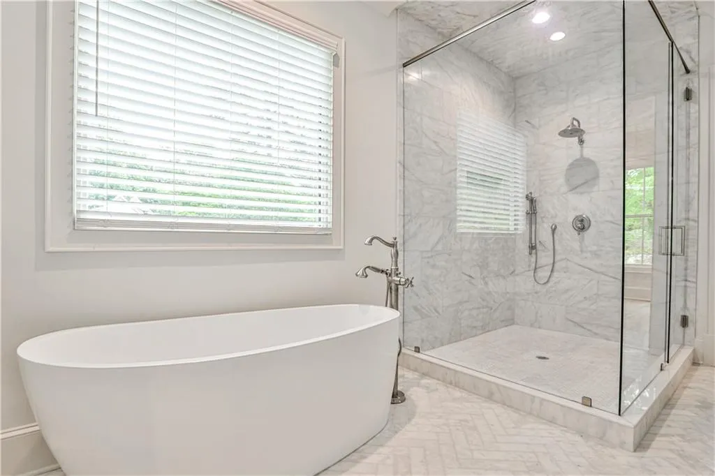 Bathroom featuring tile flooring, a healthy amount of sunlight, and shower with separate bathtub