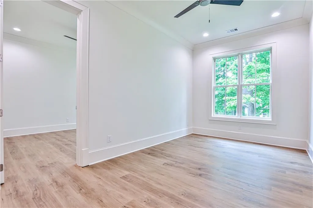 Unfurnished room featuring plenty of natural light, crown molding, light hardwood / wood-style floors, and ceiling fan