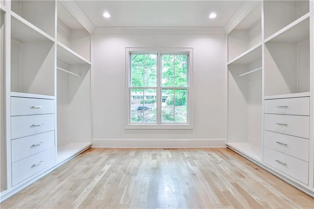 Spacious Master closet with light hardwood / wood-style floors