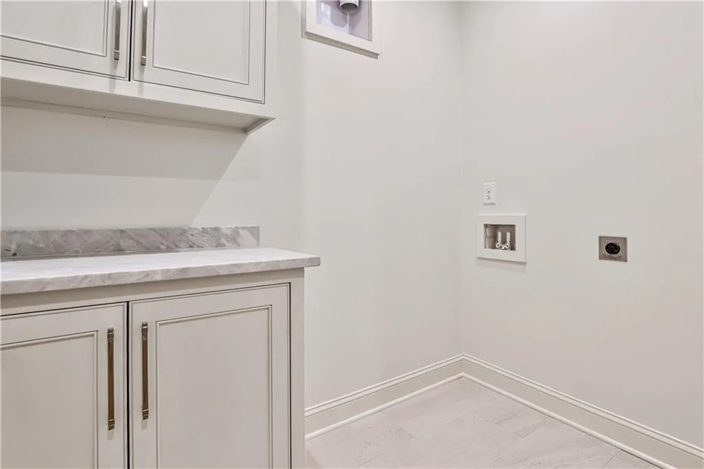 Washroom upstairs  with electric dryer hookup, cabinets, hookup for a washing machine, and light tile floors