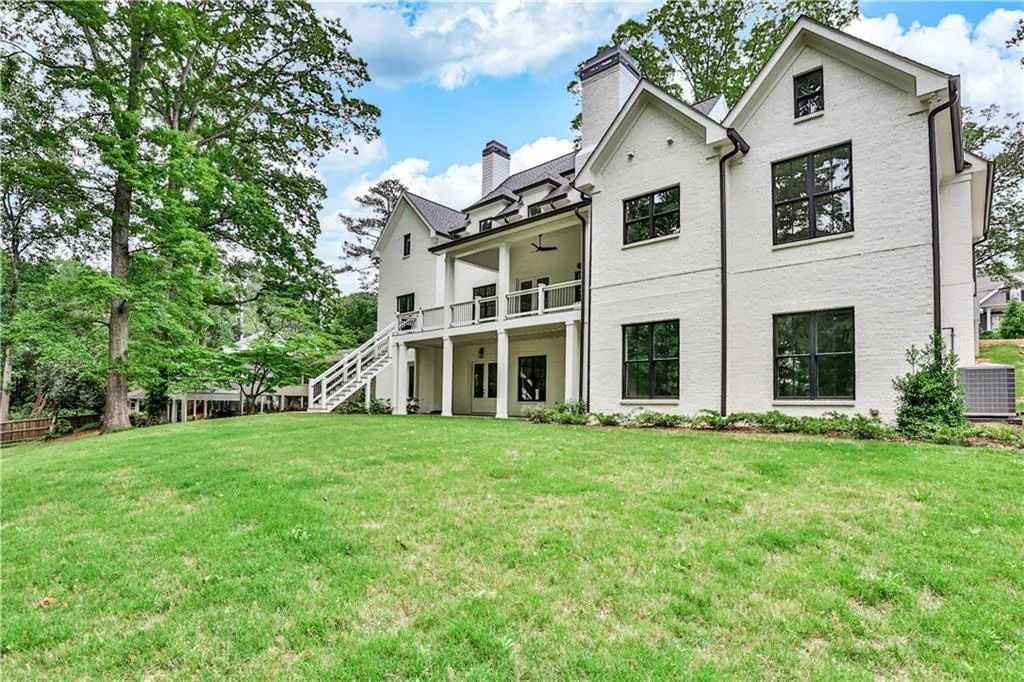 Rear view of house with a yard and central AC unit