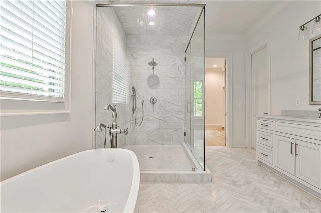 Bathroom featuring ornamental molding, shower with separate bathtub, vanity, and tile flooring