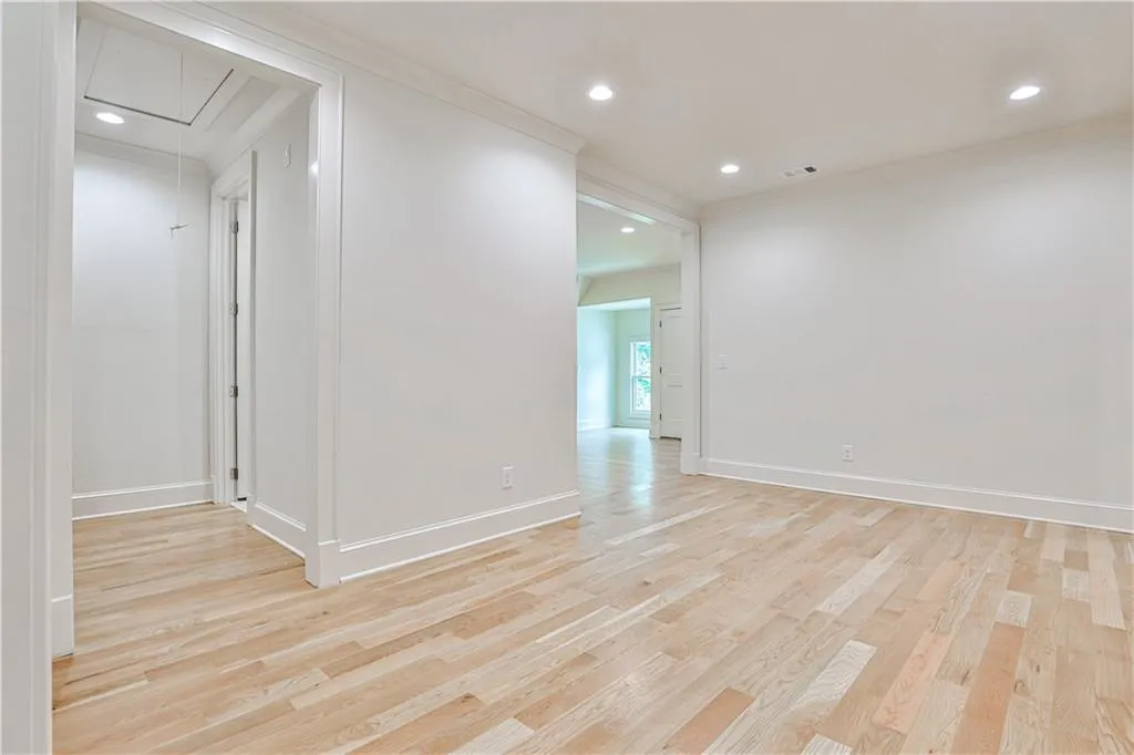 Empty room featuring ornamental molding and light wood-type flooring
