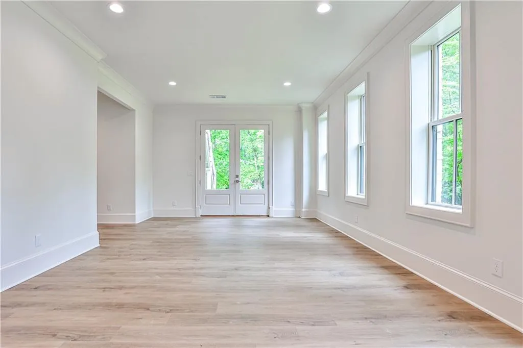 Spare room featuring light hardwood / wood-style flooring and crown molding