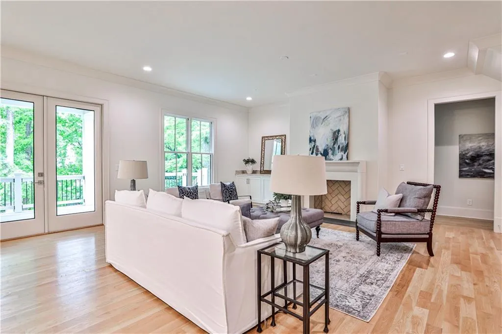 Living room featuring french doors, crown molding, and light wood-type flooring