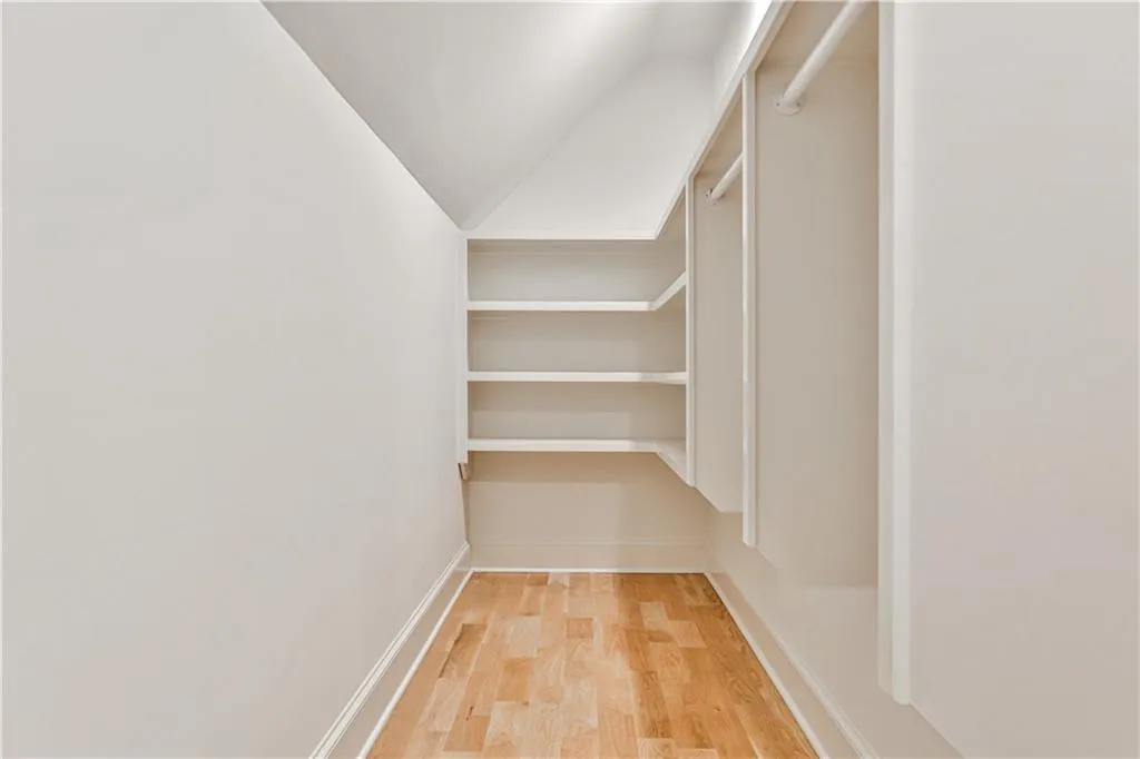 Spacious closet featuring vaulted ceiling and light wood-type flooring