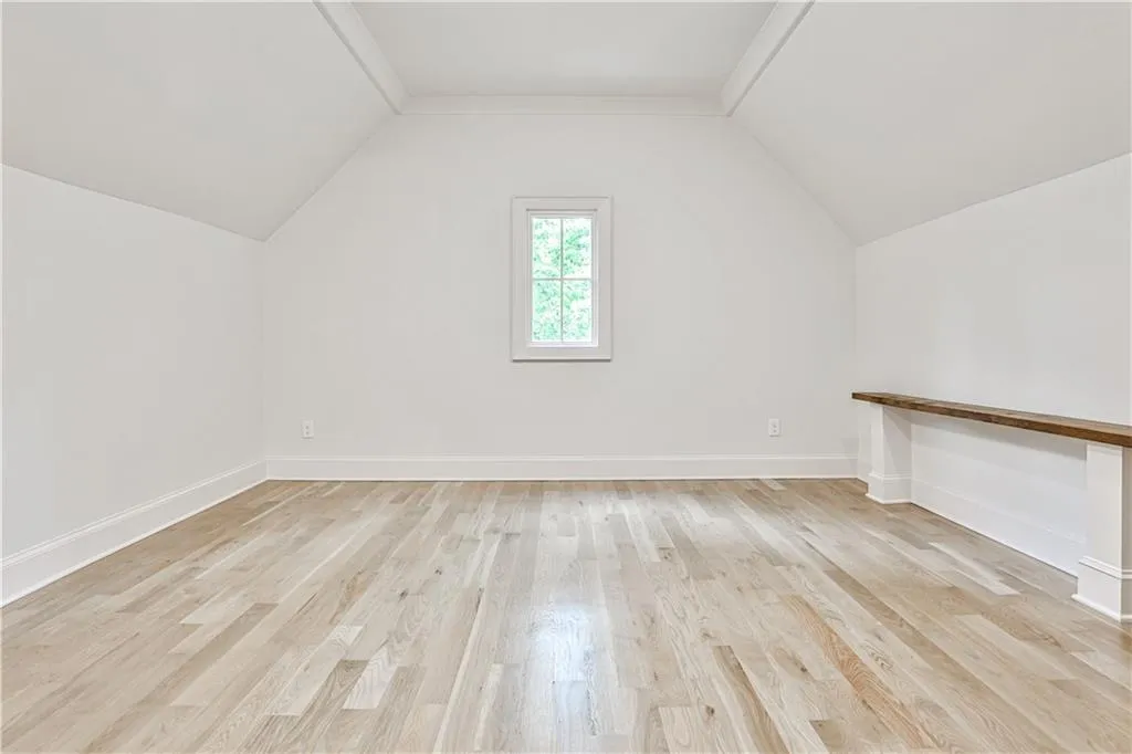 Bonus/computer/play room off one of upstairs bedrooms with light hardwood / wood-style floors and vaulted ceiling