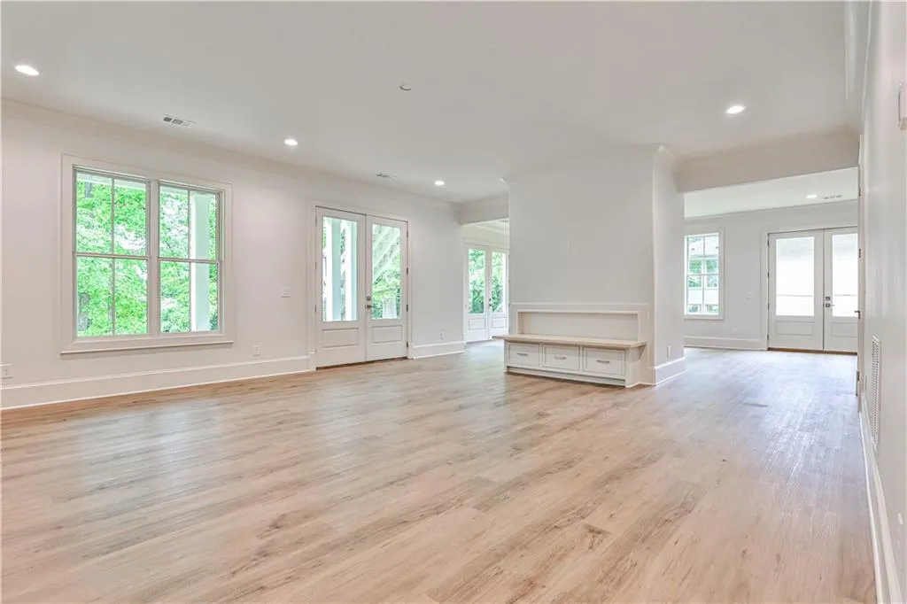 Unfurnished basement room featuring french doors, crown molding, and light wood-type flooring