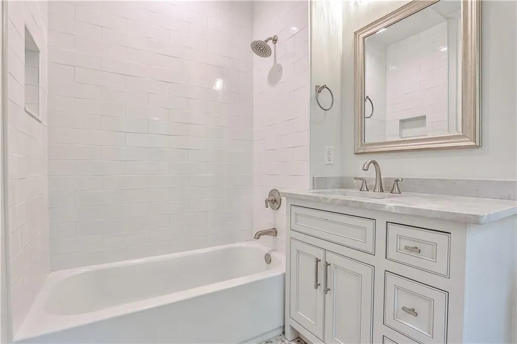 Bathroom featuring vanity and tiled shower / bath