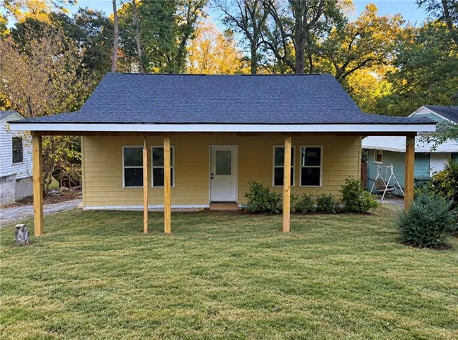 Yellow exterior siding with a dark asphalt shingle roof